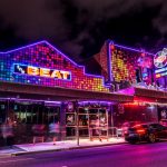 A vibrant neon lit building on a street in Sydney, hosting local gay pride events and QAF Tours and Events.