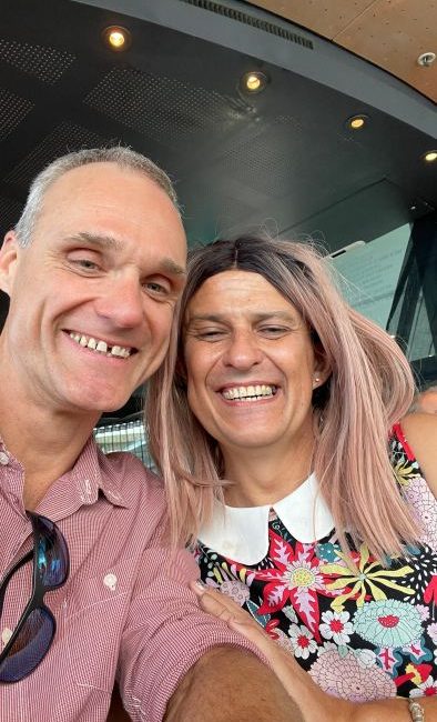 Description: A man and woman smiling for a selfie at a gay event.