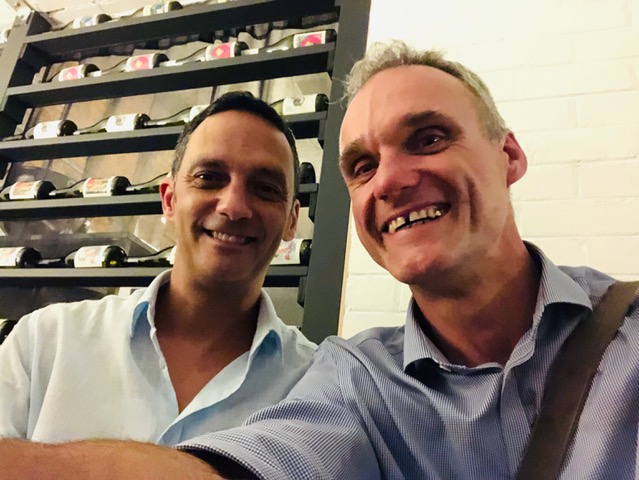 Two men capturing a memorable moment in a wine cellar, possibly during one of the local gay pride events or while on a QAF Tours and Events experience on the vibrant sunshine coast.
