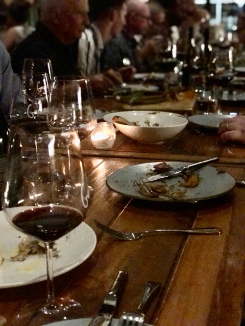 A gallery of people sitting at a long table.